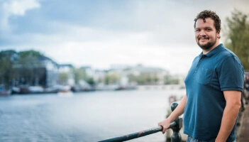 Photo of Blake Rebouche standing by a river
