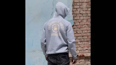 Model wearing a grey hoodie with back to the camera