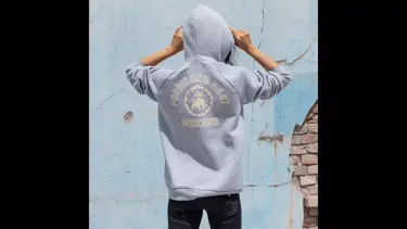 Model wearing grey hoodie with back to camera