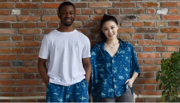 Two people stood in front of a wall wearing Horizon branded clothes