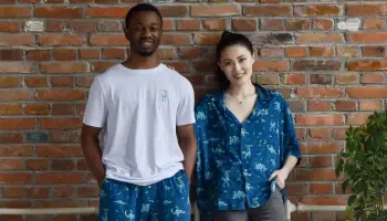 Two people stood in front of a wall wearing Horizon branded clothes